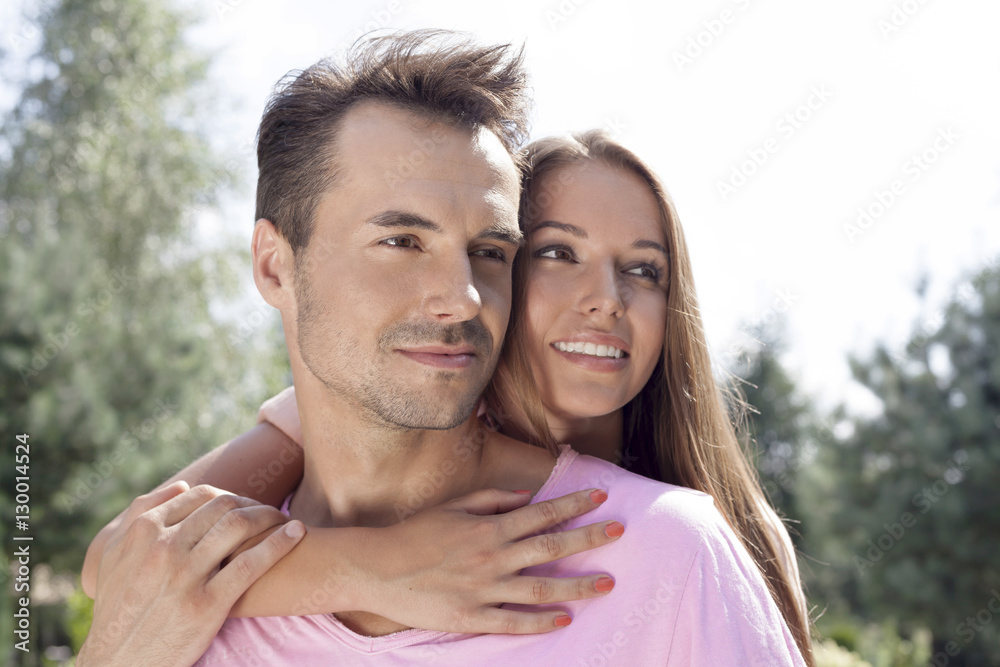 Romantic young couple looking away in park Romantic young couple looking away in park