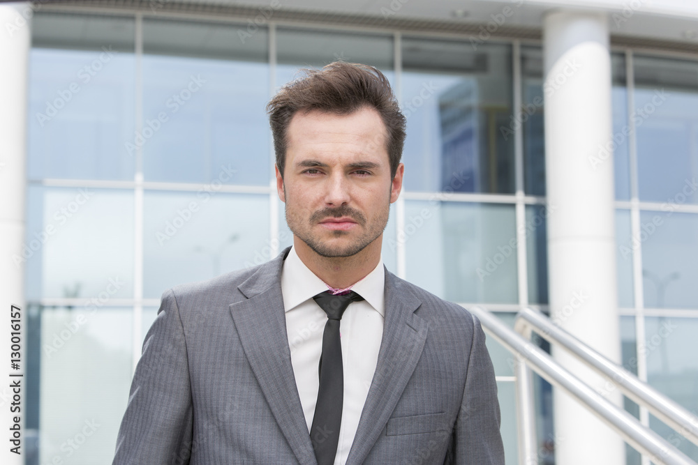 Portrait of confident young businessman standing outside office building Portrait of confident young businessman standing outside office building
