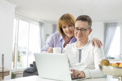 Loving couple using laptop together at home