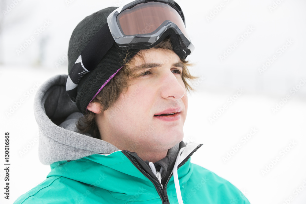 Young man wearing ski goggles outdoors Young man wearing ski goggles outdoors