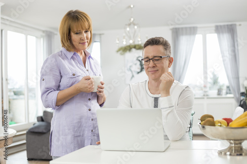 Mature couple using laptop at home