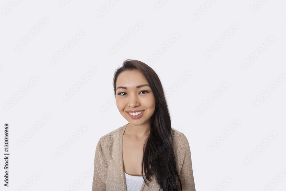Portrait of happy young woman standing against gray background Portrait of happy young woman standing against gray background