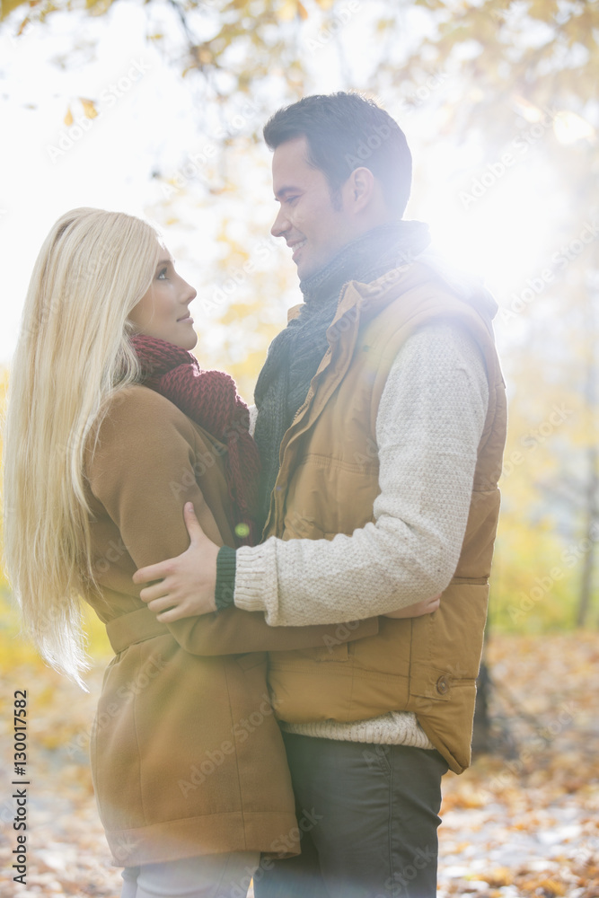 Fototapeta premium Side view of couple hugging in park