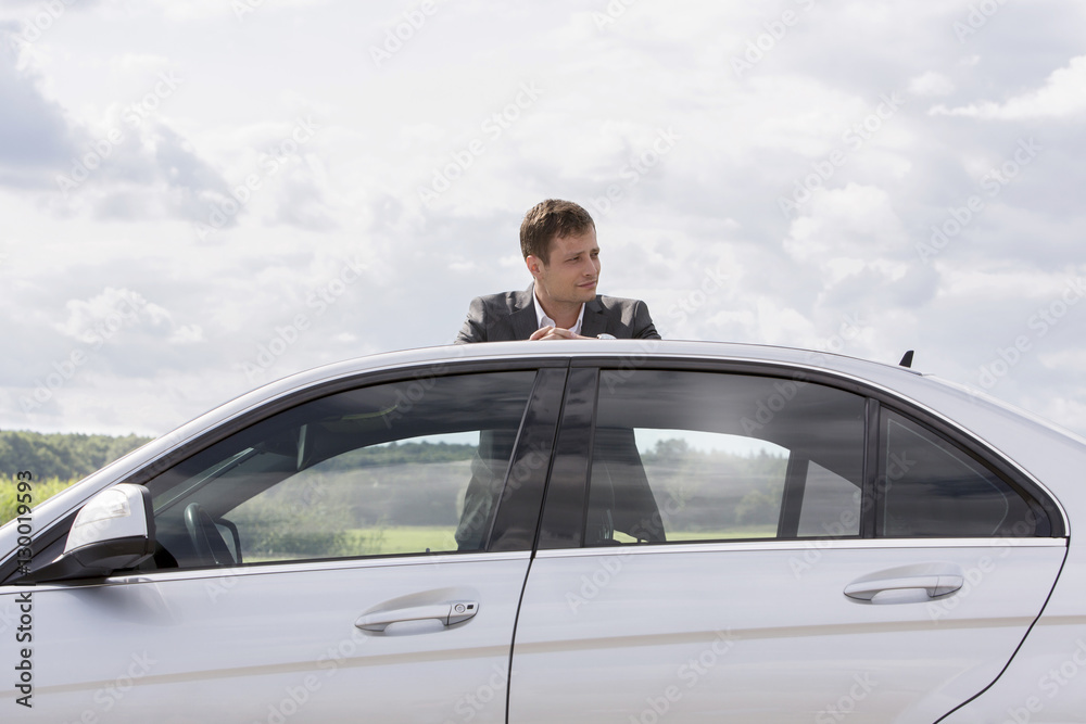 Young businessman leaning on broken down car at countryside Young businessman leaning on broken down car at countryside