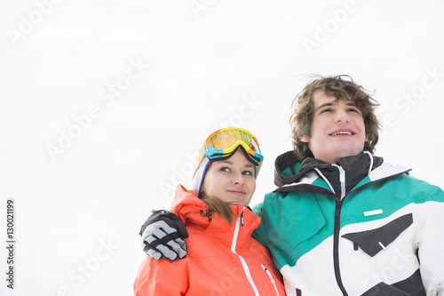 Loving young couple in warm clothing against clear sky