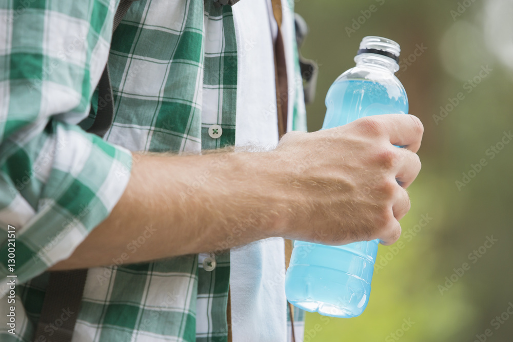 Midsection of man with energy drink outdoors