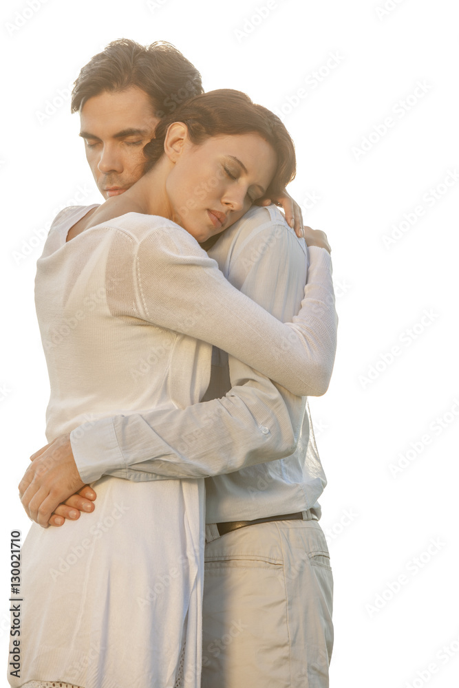Affectionate young couple with eyes closed hugging in park against clear sky Affectionate young couple with eyes closed hugging in park against clear sky