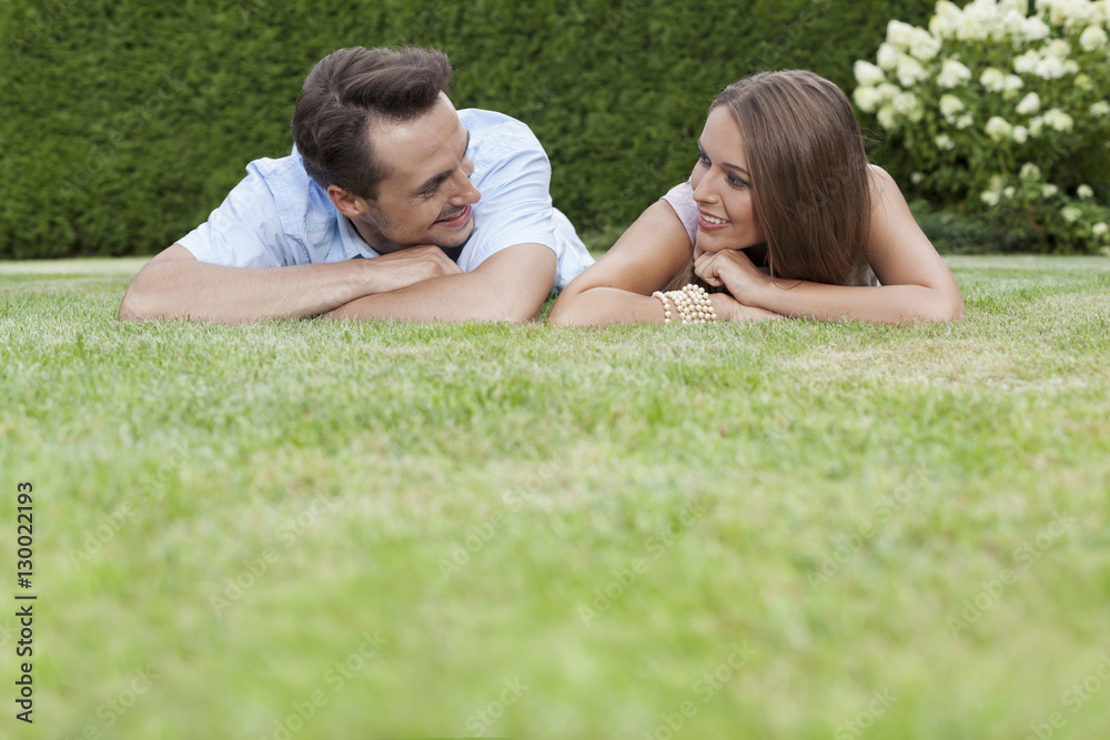 Loving young couple looking at each other while relaxing in park