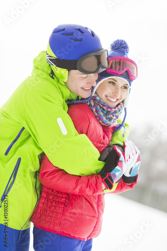 Happy loving man hugging woman in snow