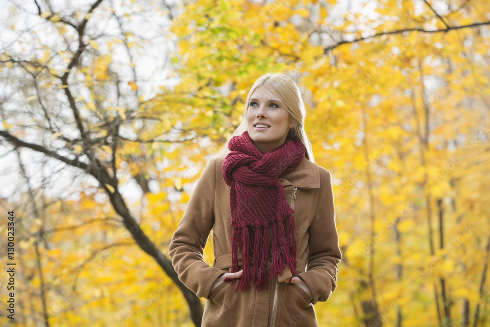 Thoughtful woman in jacket looking away at park during autumn Thoughtful woman in jacket looking away at park during autumn