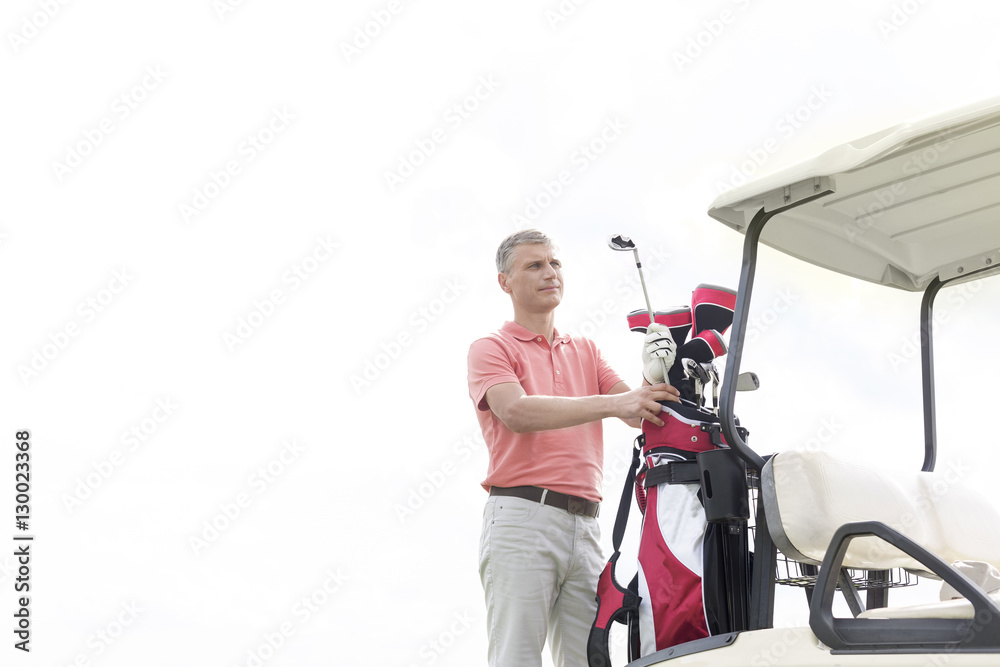 Thoughtful middle-aged man standing by cart against clear sky Thoughtful middle-aged man standing by cart against clear sky