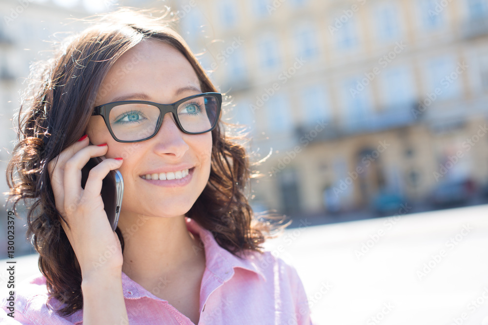 Happy young woman looking away while using smart phone on sunny day Happy young woman looking away while using smart phone on sunny day