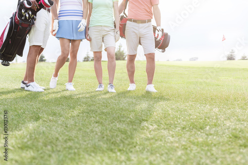 Low section of friends standing at golf course