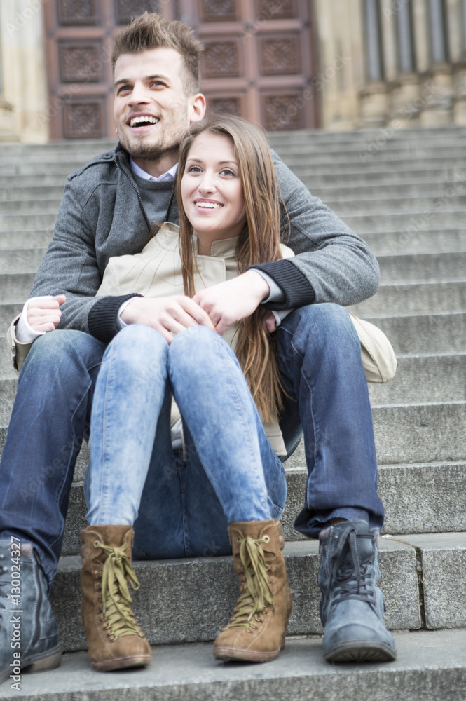 Full length of young couple sitting on steps outdoors Full length of young couple sitting on steps outdoors