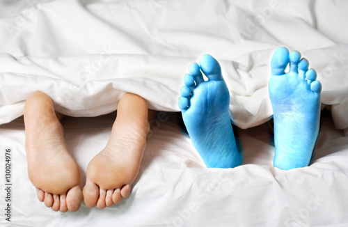 Closeup of a couple lying in bed barefeet photo