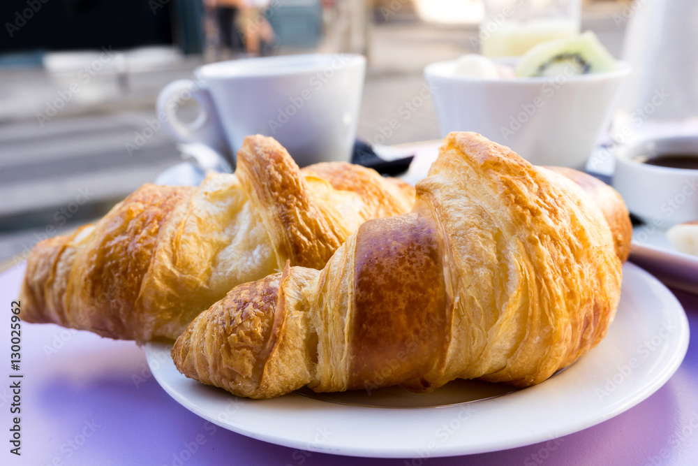 Breakfast with coffee and croissants on table