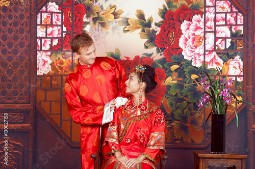 Canvas Print Mixed Race Bride and Groom in Studio wearing traditional Chinese wedding outfits