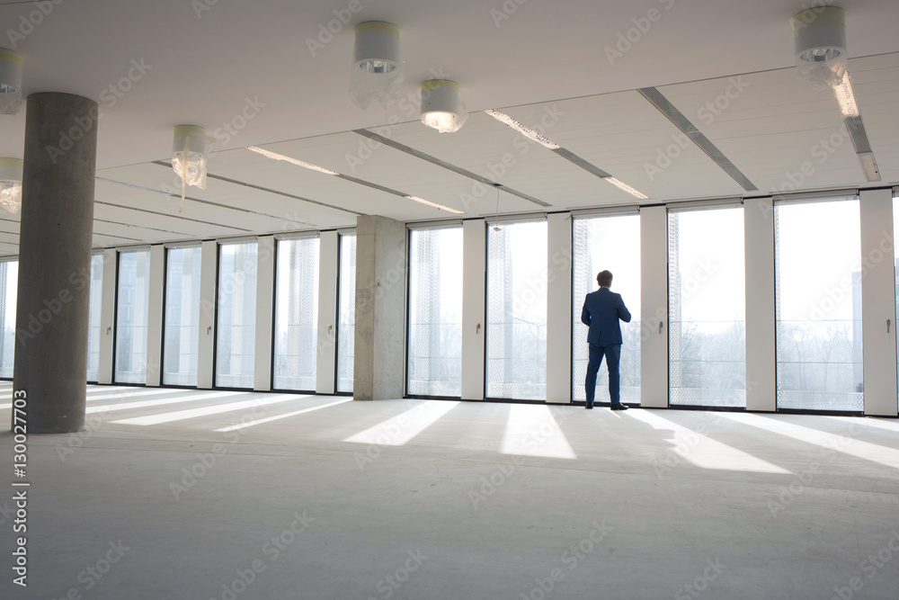 Rear view of mature businessman visiting empty office space