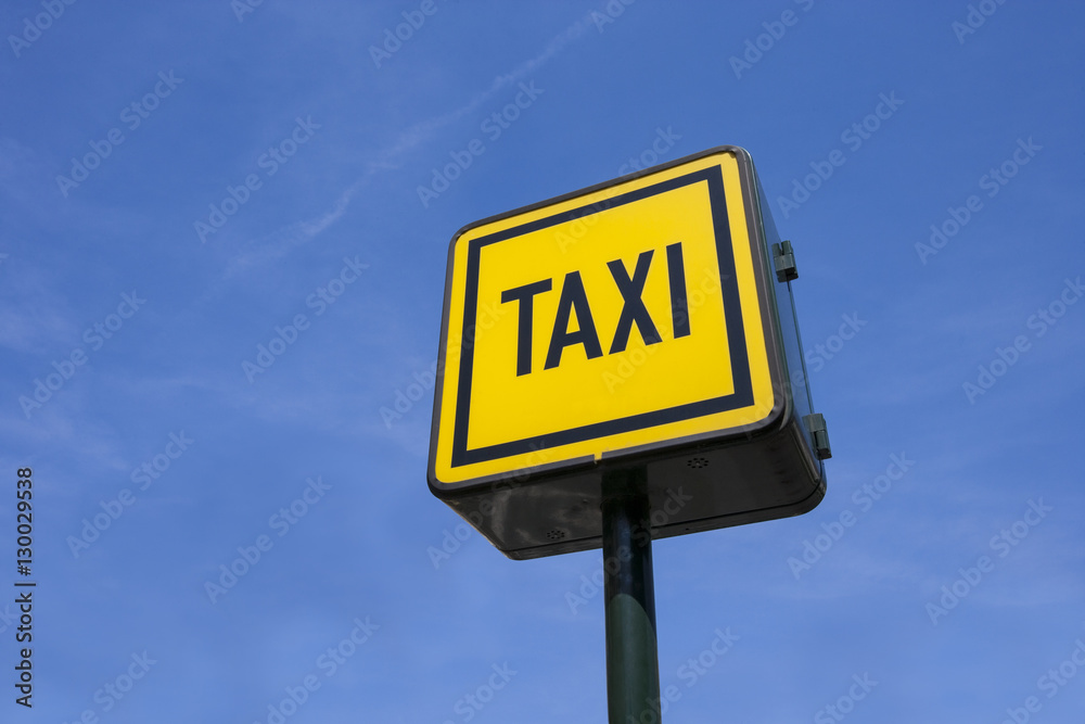 Low angle view of taxi sign against blue sky Low angle view of taxi sign against blue sky