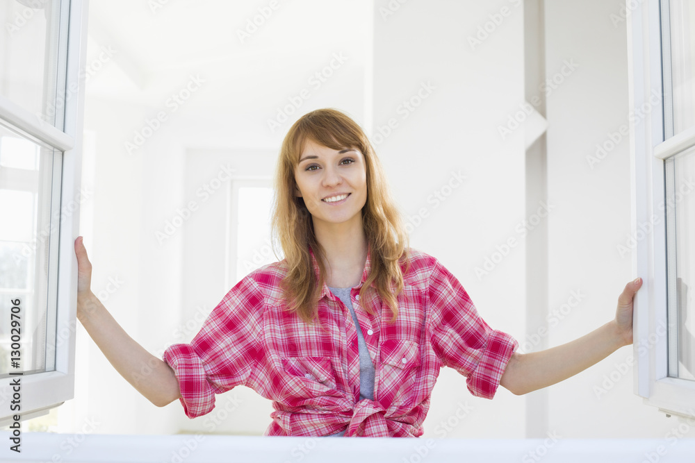 Smiling woman looking through window Smiling woman looking through window