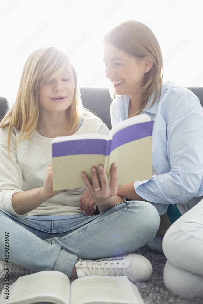 Mother assisting daughter in homework at home Mother assisting daughter in homework at home