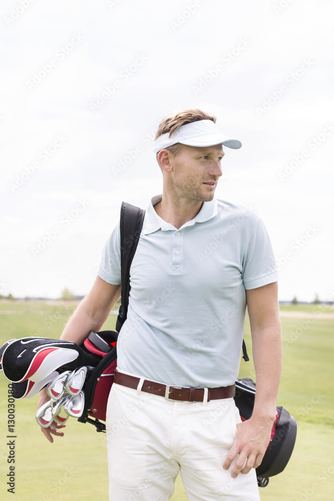 Thoughtful mid-adult man carrying golf club bag against clear sky Thoughtful mid-adult man carrying golf club bag against clear sky