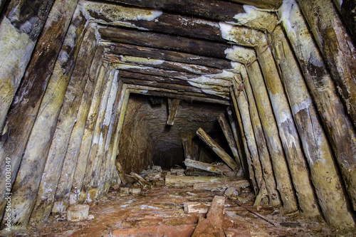 Undreground abandodned mine tunnel shaft with wooden mounting frame lining photo