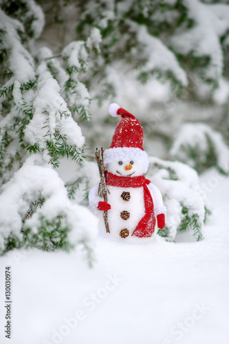 christmas toy of the snowman in snow covered forest