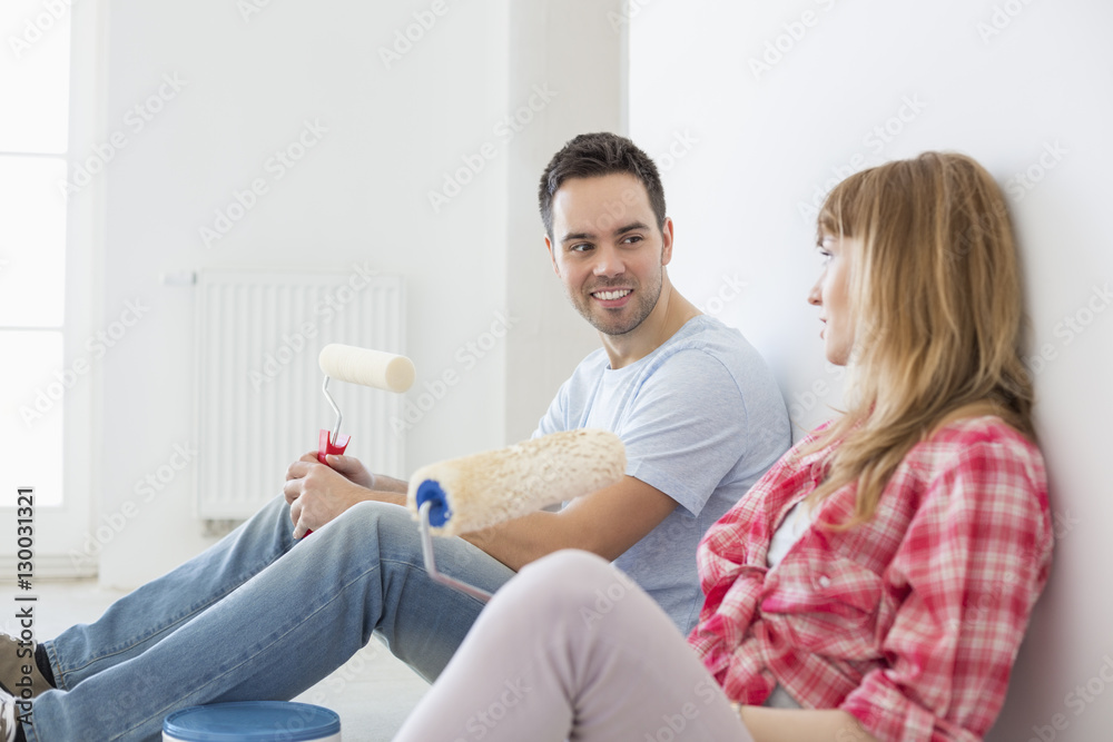 Couple taking break from painting in new home Couple taking break from painting in new home
