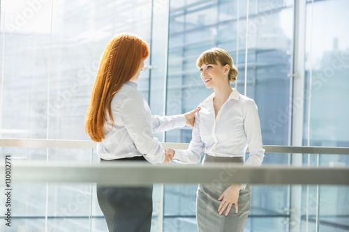 Businesswomen shaking hands in office