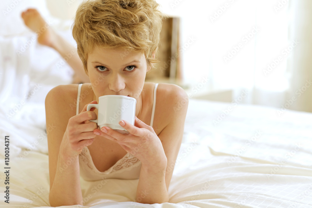 Woman drinking coffee in bed Woman drinking coffee in bed