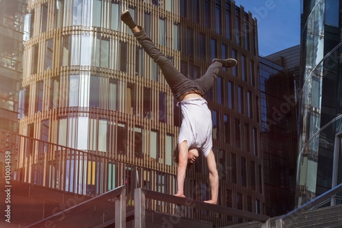 Young man doing handstand in the city
