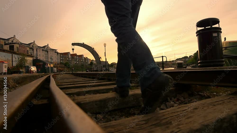 lonely man walking in the middle of an old railway
