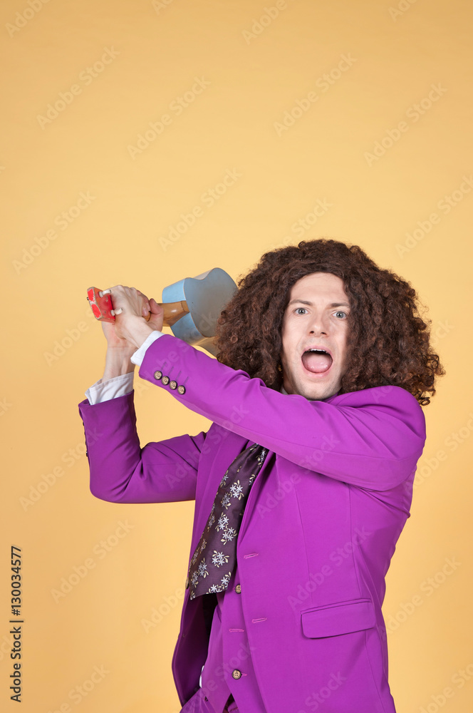 Caucasian man with afro wearing Purple Suit with guitar behind his head Caucasian man with afro wearing Purple Suit with guitar behind his head