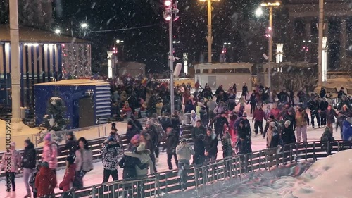 People skate on the rink outdoors photo