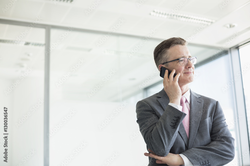 Midsection of mature businessman buttoning sleeve Midsection of mature businessman buttoning sleeve