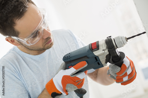 Canvastavla Mid-adult man drilling in wall