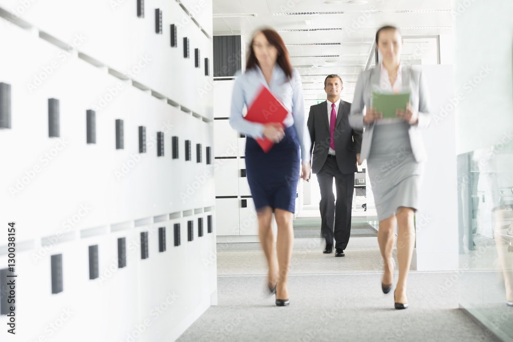 Obraz premium Blurred view of businesswomen walking in office