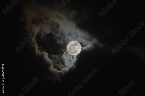 Bright full moon on cloudy scene of night sky