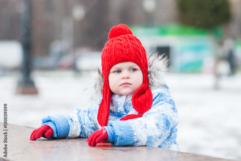 Little girl draws on a marble slab and looks in the direction of Little girl draws on a marble slab and looks in the direction of