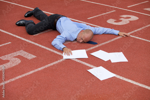 View of a businessman lying on a race track photo