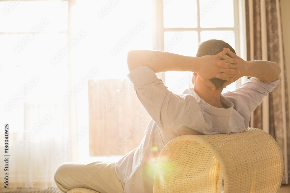 Rear view of man relaxing on chair at home Rear view of man relaxing on chair at home