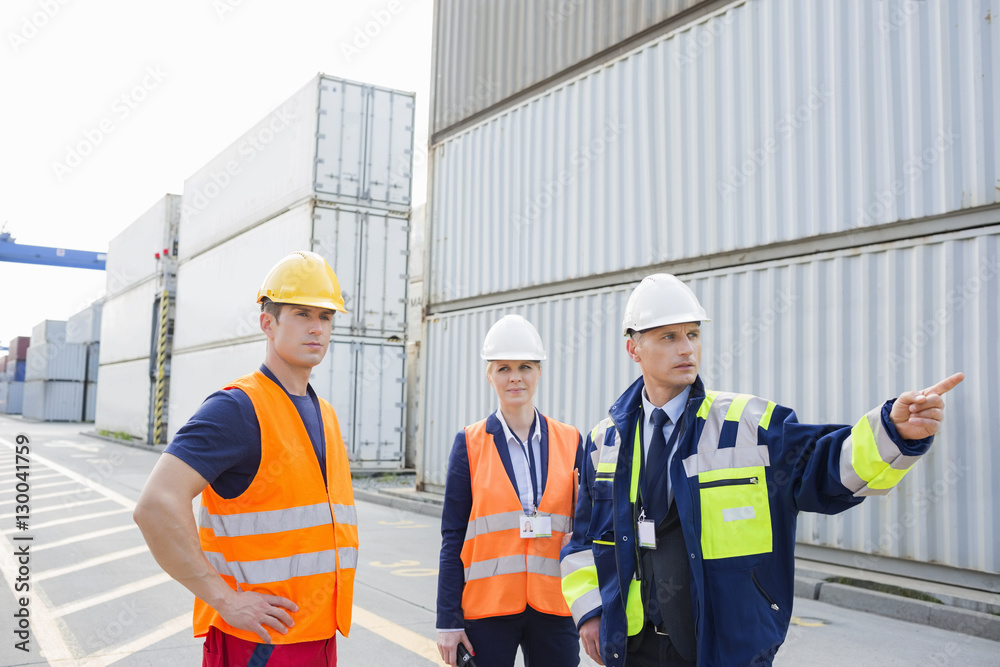 Workers discussing in shipping yard Workers discussing in shipping yard