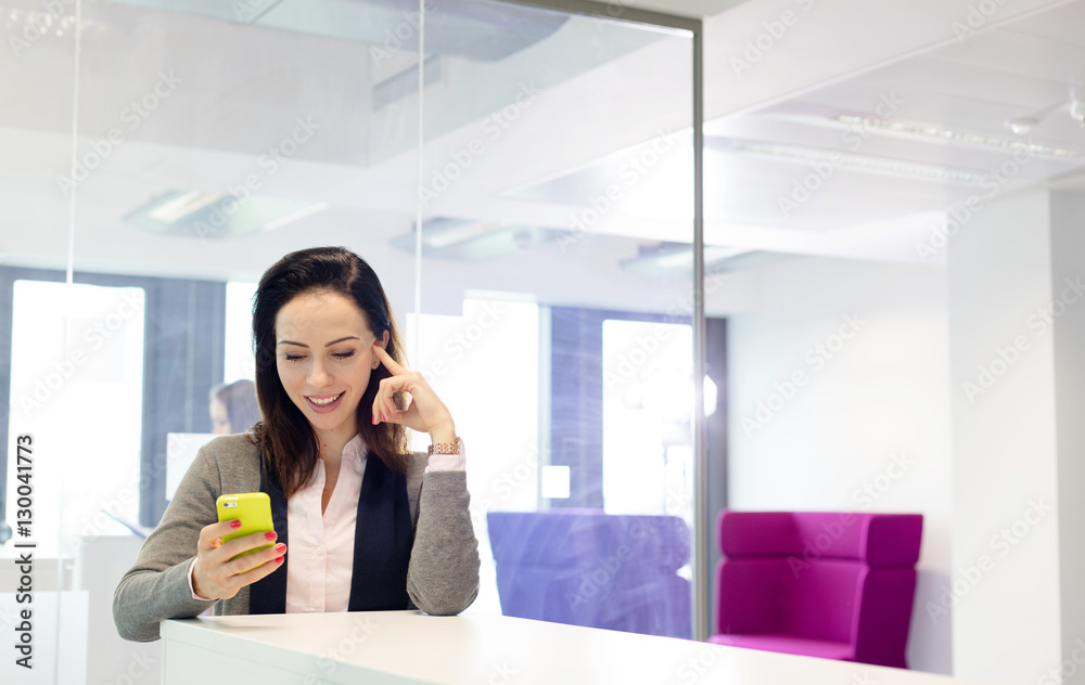 Beautiful young businesswoman using mobile phone in office Beautiful young businesswoman using mobile phone in office