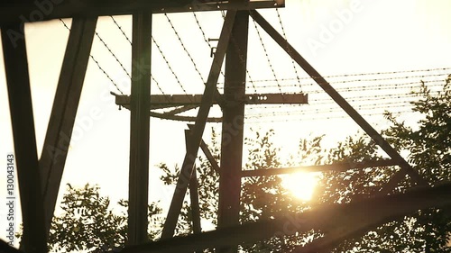 Large fences and barbed wire against a sunset sky  photo