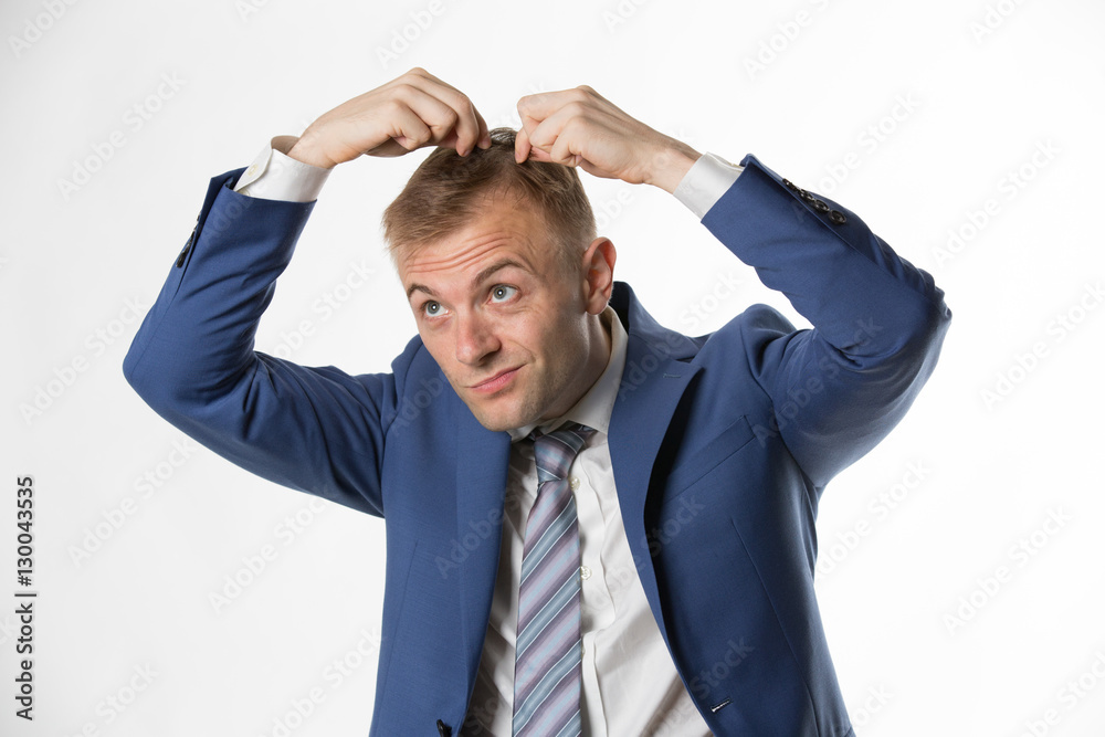 Businessman checking his hair indicating hair loss Businessman checking his hair indicating hair loss