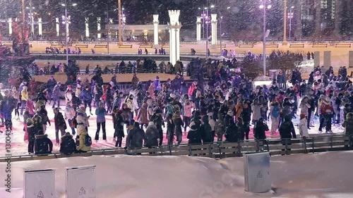 People skate on the rink outdoors photo