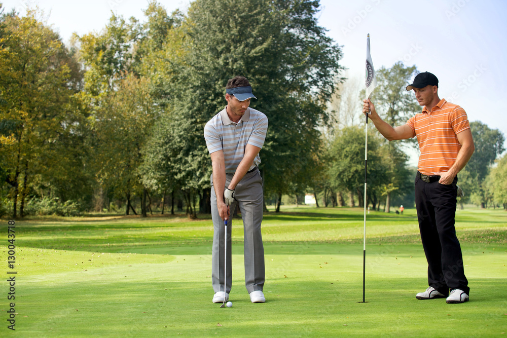 Obraz premium Young man with his friend playing golf in golf course