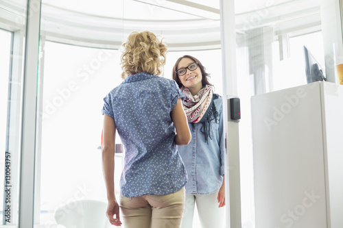 Happy businesswomen conversing in creative office © moodboard