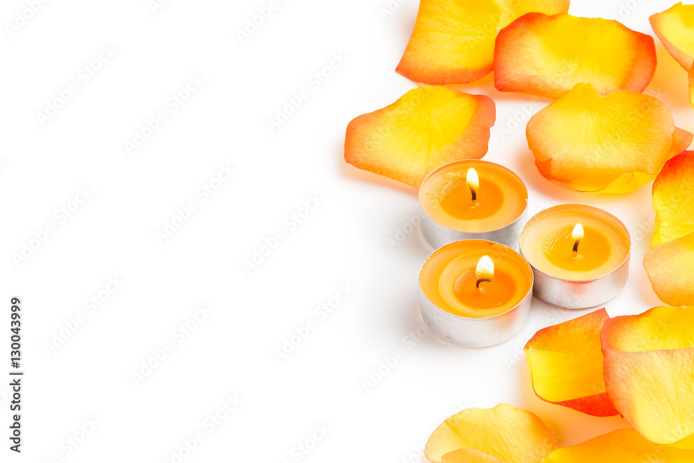burning small candles with rose petals and copy space on a white